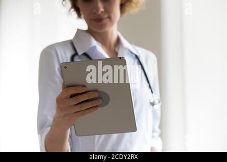 Close up focused woman professional doctor holding digital tablet Stock Photo