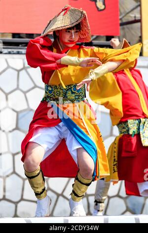 Close up of a young Japanese woman on stage in yukata tunic and farmer's straw hat dancing during the Kyusyu Gassai yosakoi festival in Japan. Stock Photo