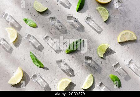 Fresh mint leaf and ice cubes with droplets and lime on background Stock Photo