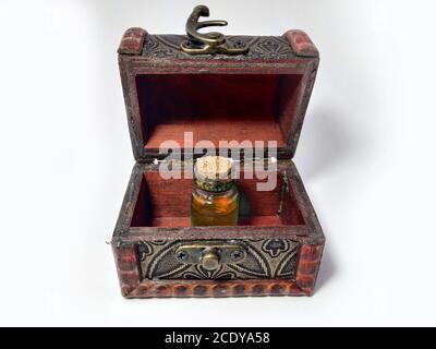 Wood chest with potion orange. old treasure casket isolated on white background. Alchemy set with flasks. small glass bottles with colored liquid for Stock Photo