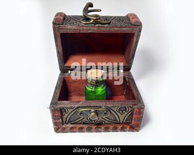 Wood chest with potion green. old treasure casket isolated on white background. Alchemy set with flasks. small glass bottles with colored liquid for g Stock Photo