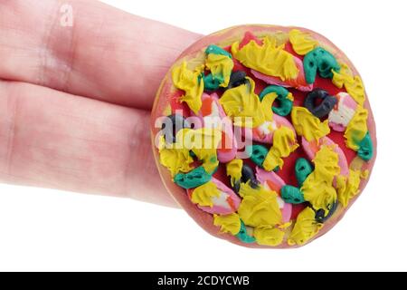 In the future we will eat this concept. Mini pizza made of clay plasticine on fingers  isolated Stock Photo