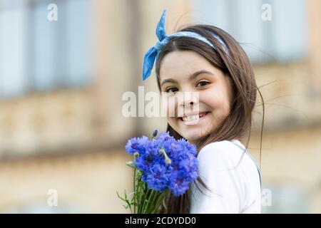 Little girl cornflowers bouquet holiday greetings, simple happiness concept. Stock Photo