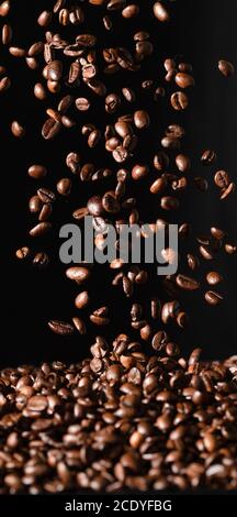 Falling coffee beans isolated on black background Stock Photo