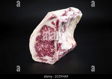 Raw dry aged wagyu cote de boeuf beef block as closeup on black background with copy space Stock Photo