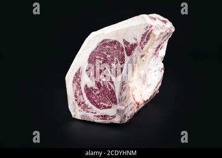 Raw dry aged wagyu cote de boeuf beef block as closeup on black background with copy space Stock Photo