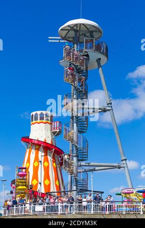 Bournemouth, Dorset UK. 30th August 2020. UK weather: warm with sunny intervals at Bournemouth beaches as beachgoers head to the seaside for the long Bank Holiday weekend. Beaches are fairly busy, but not packed. People at the end of the pier watching activity at sea with helter skelter ride and people climbing up the launch tower to do a zip line ride. Credit: Carolyn Jenkins/Alamy Live News Stock Photo