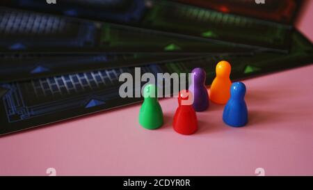 Colored board game figures on pink background Stock Photo