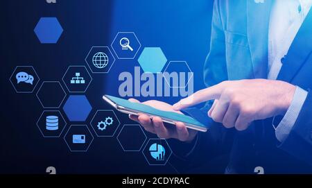 Data Management And Modern Technologies. Multimedia icons cells around businessman using smartphone Stock Photo