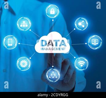 Man Clicking On Data Management Cloud On Digital Screen With Multimedia Icons Stock Photo