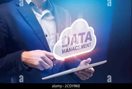 Business Data Management. Businessman Holding Digital Tablet With Storage Cloud Hologram Above Stock Photo