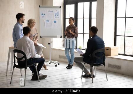 Focused young skilled indian female trainer giving educational marketing lecture. Stock Photo