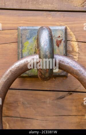 Ancient rusty ring on a cracked weathered wooden board close up Stock Photo