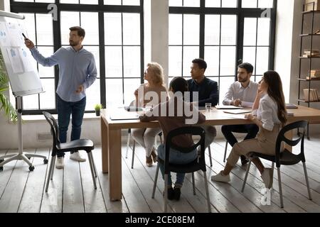 Skilled young sales trainer giving educational lecture to business people. Stock Photo