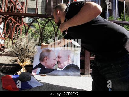 Kiev, Ukraine. 30th Aug, 2020. An activist places a placard of Russian President Vladimir Putin and Belarusian President Alexander Lukashenko during a rally of solidarity with the Belarusian protests against the results of the presidential elections, in front of the Belarusian embassy in Kiev, Ukraine 30 August 2020. Credit: Serg Glovny/ZUMA Wire/Alamy Live News Stock Photo