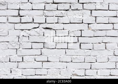 rough white brick wall with leaking plaster background Stock Photo