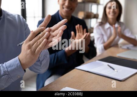 Close up happy diverse business people clapping hands. Stock Photo