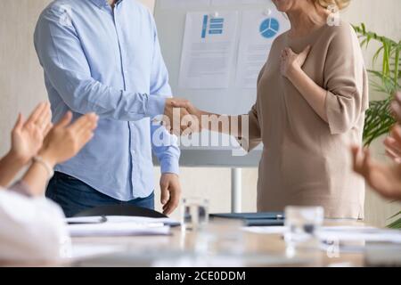 Young businessman shaking hands with older senior employee. Stock Photo