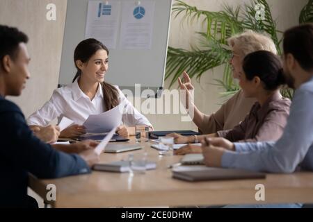 Smiling young arabian female leader holding brainstorming meeting. Stock Photo