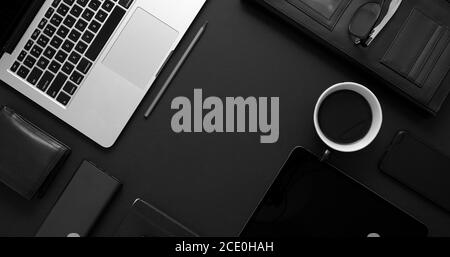 Business desktop concept. Mix of office supplies and gadgets on a black table background Stock Photo