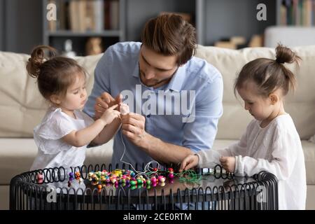 Happy parent involved in handmade activity with small kids girls. Stock Photo