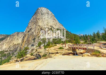 Liberty Cap peak and Bridge of Nevada Fall waterfall on Merced River from John Muir trail in Yosemite National Park. Summer travel holidays in Stock Photo