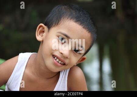 Cute little cheerful asian child looking at the camera, close up shot, eyes ear nose mouth Stock Photo