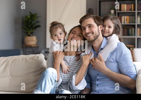 Loving small baby girls embracing smiling parents. Stock Photo