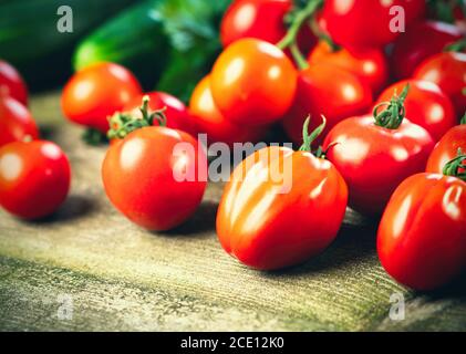 Harvest of fresh ripe tomatoes on wooden table. Healthy organic food, summer vitamins, BIO viands, natural background.
