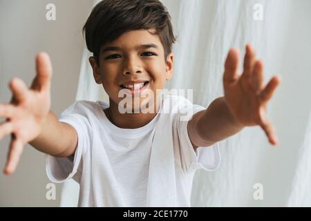 Friendly indian asian kid with arms outstretched, wanting to hug. Stock Photo