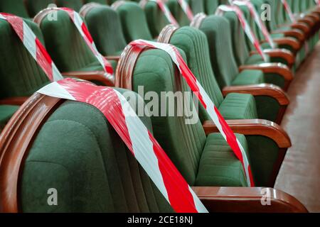 Background of empty seats in the cinema, theater, auditorium with a warning label. Presentation of a conference, opera, theatrical performance. Work Stock Photo
