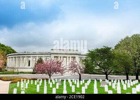 The Arlington Memorial Amphitheater over National Cemetery tombstones with blooming cherry trees, Virginia Stock Photo