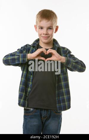 A boy of ten years shows a heart with two hands on his chest Stock Photo