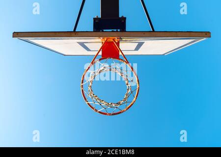 Street basketball hoop on a sunny day with blue sky in the background. Urban youth game. Concept of success, scoring points and winning Stock Photo