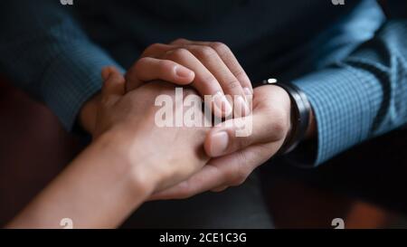 Close up African American man comforting woman, holding hands Stock Photo