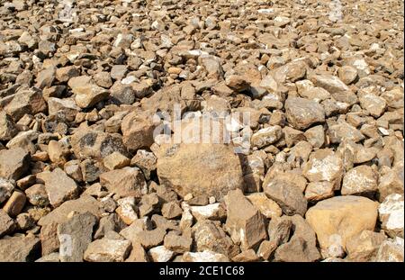 Grey dark stones background. Backdrop made of many differebt sizes stones. Stock Photo