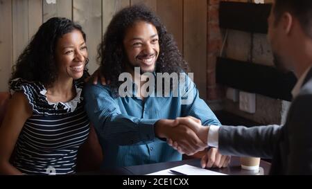 Smiling African American man shaking realtor hand, family making deal Stock Photo