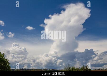 Dramatic cloud formation with threatening thunderclouds in front of still blue sky Stock Photo