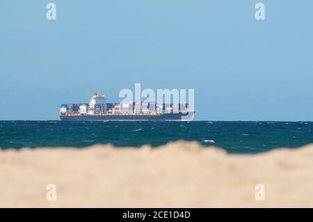 View of a loaded container cargo freight ship on the sea in Australia Stock Photo