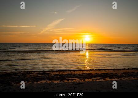 Beautiful golden sunset at the beach. Sun setting into the sea on tranquil evening. Nobody Stock Photo