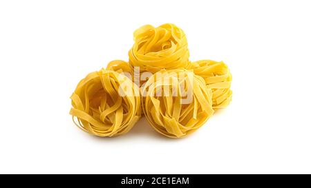 Uncooked fettuccine nest pasta on white background. Stock Photo