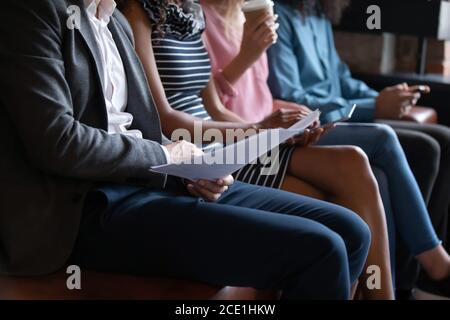 Close up diverse candidates sitting in row, using gadgets Stock Photo