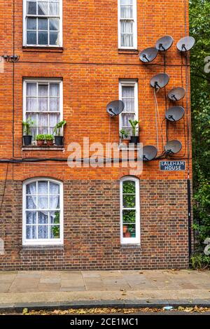 Multiple satellite TV dishes affixed to 1890s era building in Arnold Circus, East London. Stock Photo
