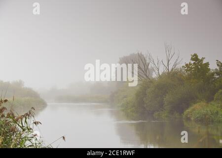 Autumn weather. Overcast rainy dawn. Cloudy sunrise. Haze and mist over water. Fog over river Neman, Belarus Stock Photo