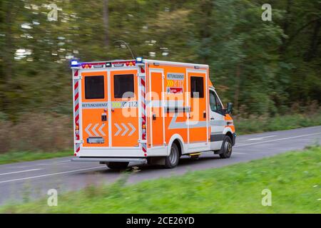 Cologne, NRW, Germany, 08 29 2020, ambulance car driving down a country road, alarm lights are on Stock Photo