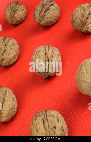Arrangement of a group of organic walnuts on a red background Stock Photo