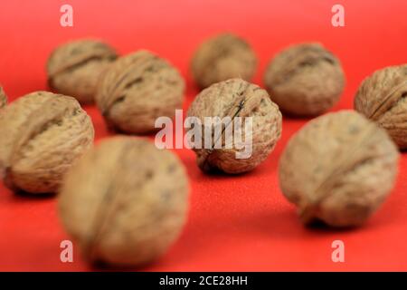 Arrangement of a group of organic walnuts on a red background Stock Photo