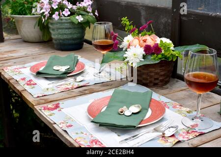 Secluded outdoor patio cafe setting in beautifully landscaped garden on lovely summer evening to enjoy al fresco meal Stock Photo