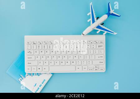 Booking and search flight ticket air international travel concept, keyboard, passport and airplane on blue background. Summer or vacation concept Stock Photo