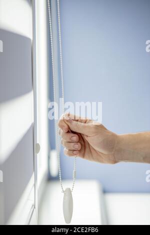 Man testing cassette roller blinds on windows. Stock Photo
